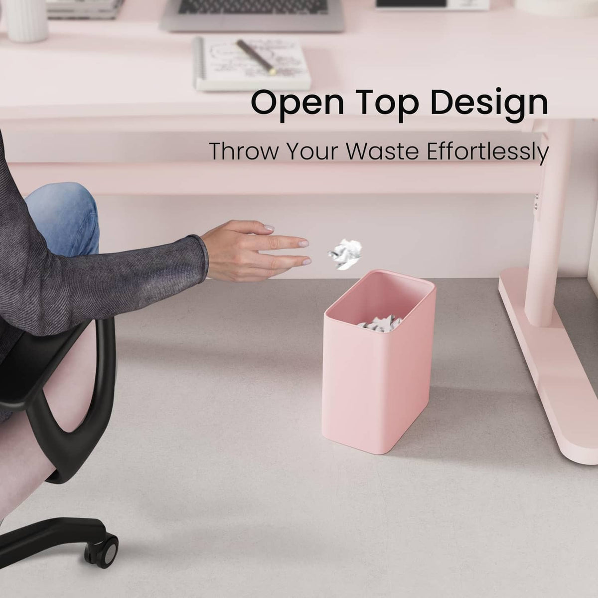 Pink open-top trash can receiving paper scraps