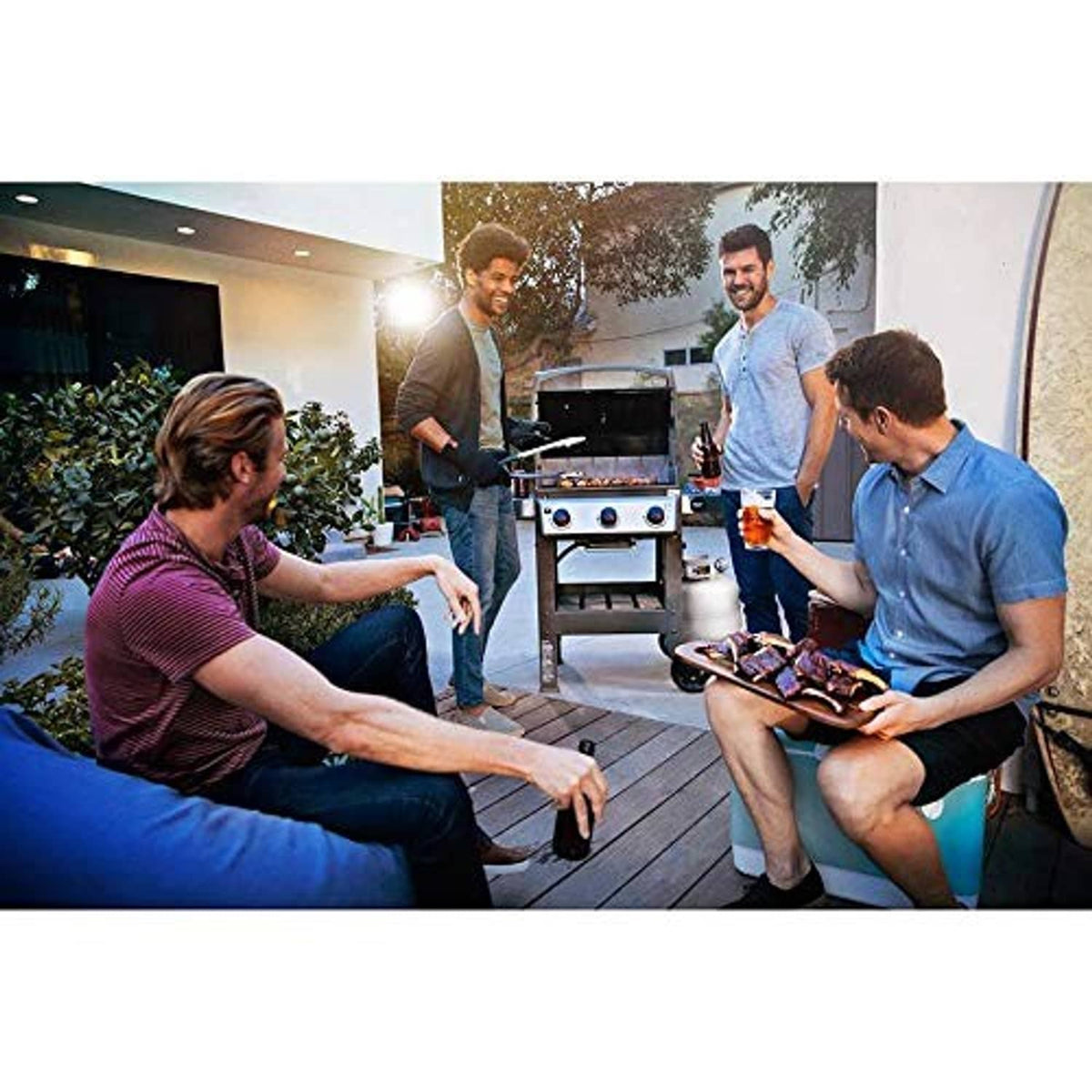 Group using stainless gas grill outdoors during evening get-together