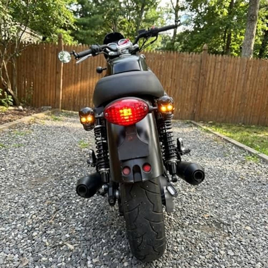 Amber LED turn signals on black motorcycle, skull-style housings with glowing lenses