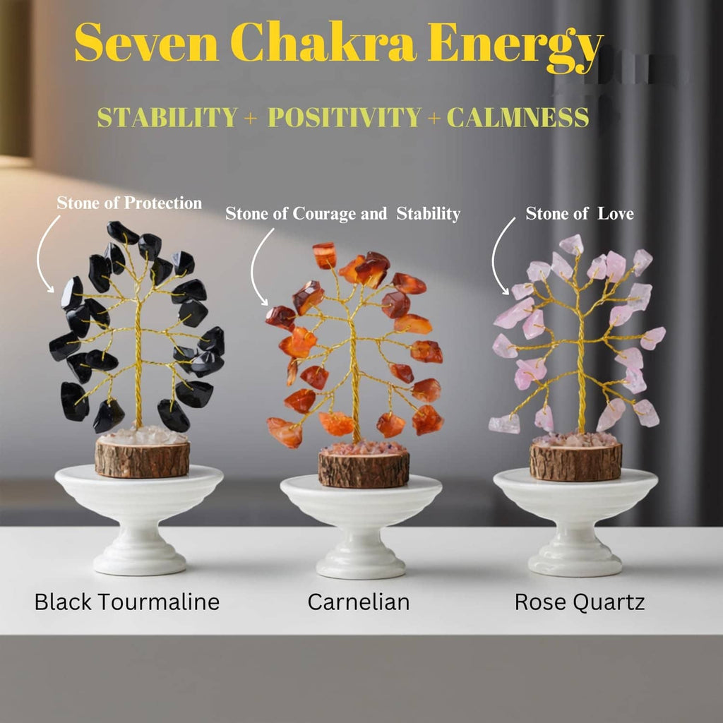 Three chakra crystal trees on white pedestals: black tourmaline, carnelian, rose quartz.
