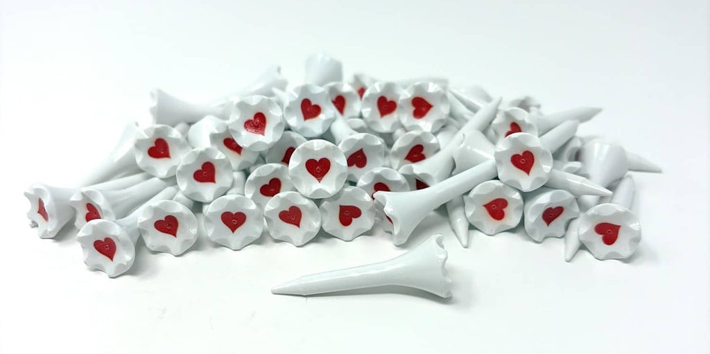 White plastic golf tees stacked, each with red heart head