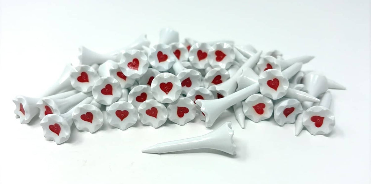White plastic golf tees stacked, each with red heart head