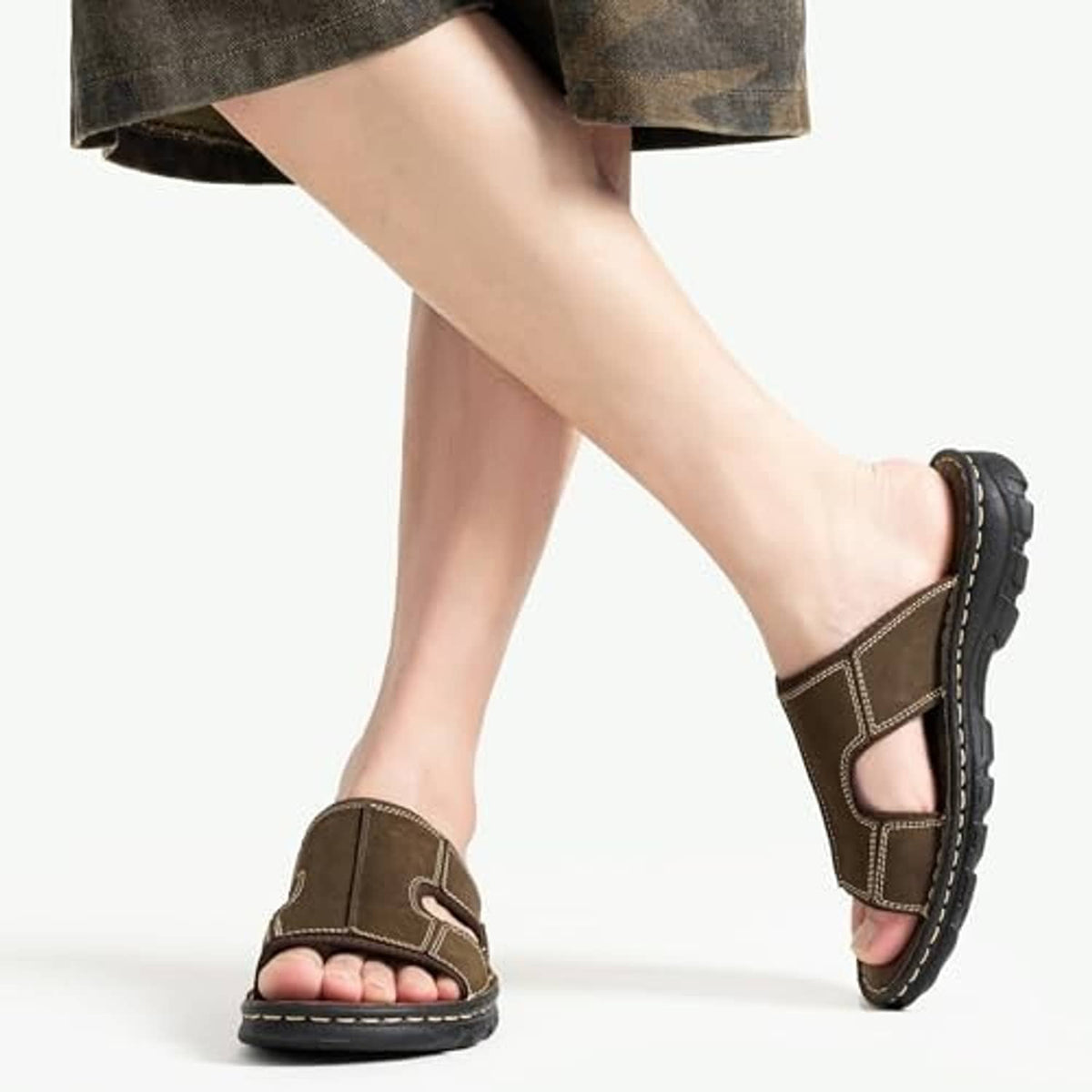 Men's dark brown leather slip-on sandals worn with open-toe upper and stitched strap details
