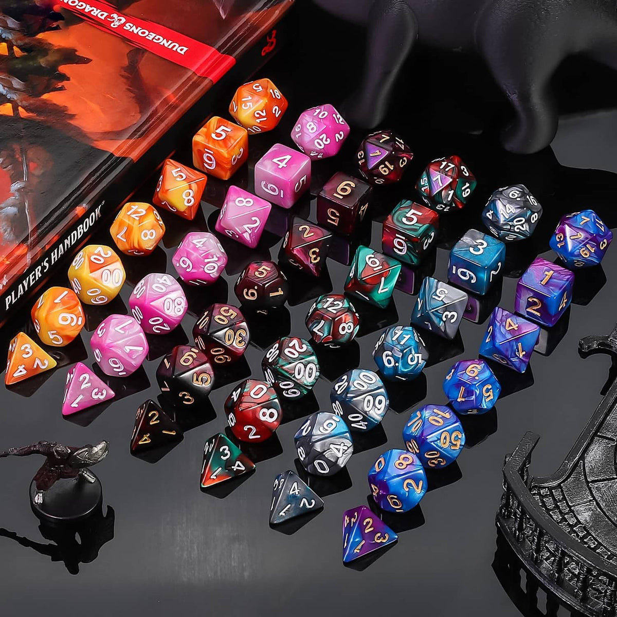 Scattered multicolor polyhedral RPG dice on a tabletop, with many numbers visible