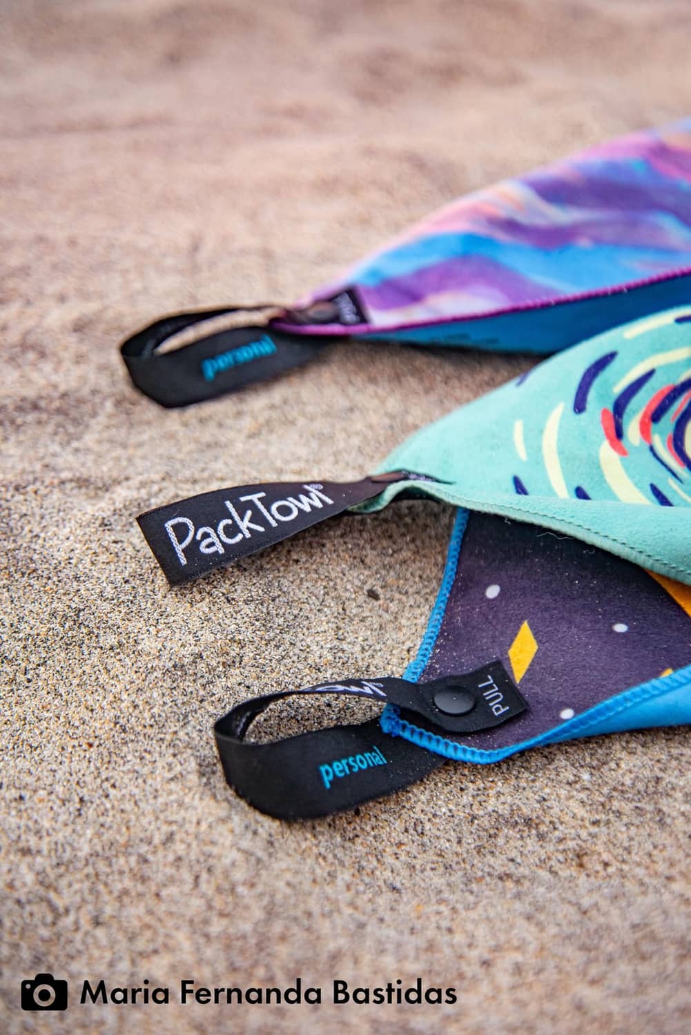 Ultralight body towel roll with PackTowl label on teal and purple Desert Aire print.