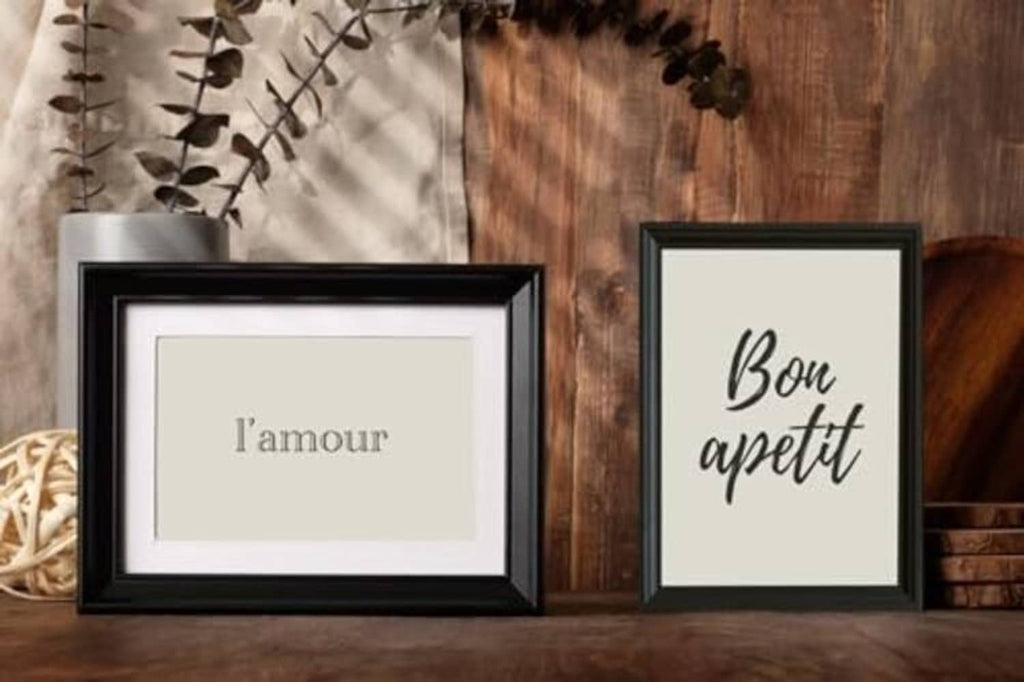 Two black picture frames with white mats and real glass display