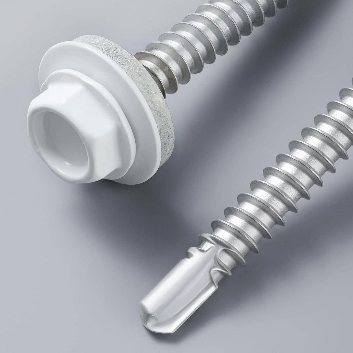 Close-up metal roofing screw with EPDM washer and external hex head, silver threads and white cap