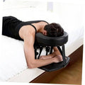 Black padded massage headrest with armrest on adjustable metal stand for beds