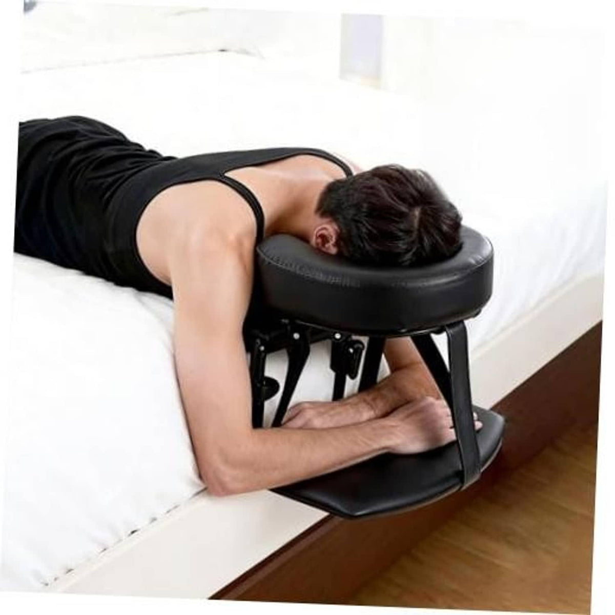 Black padded massage headrest with armrest on adjustable metal stand for beds