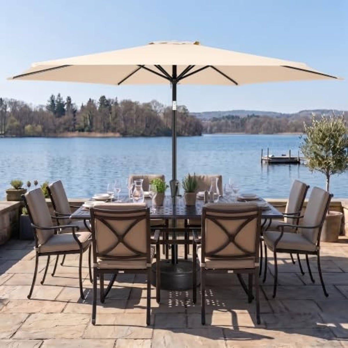 Beige patio umbrella over lakeside outdoor dining set