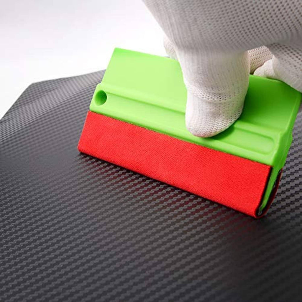 Hand using green felt squeegee with red pad on dark vinyl surface