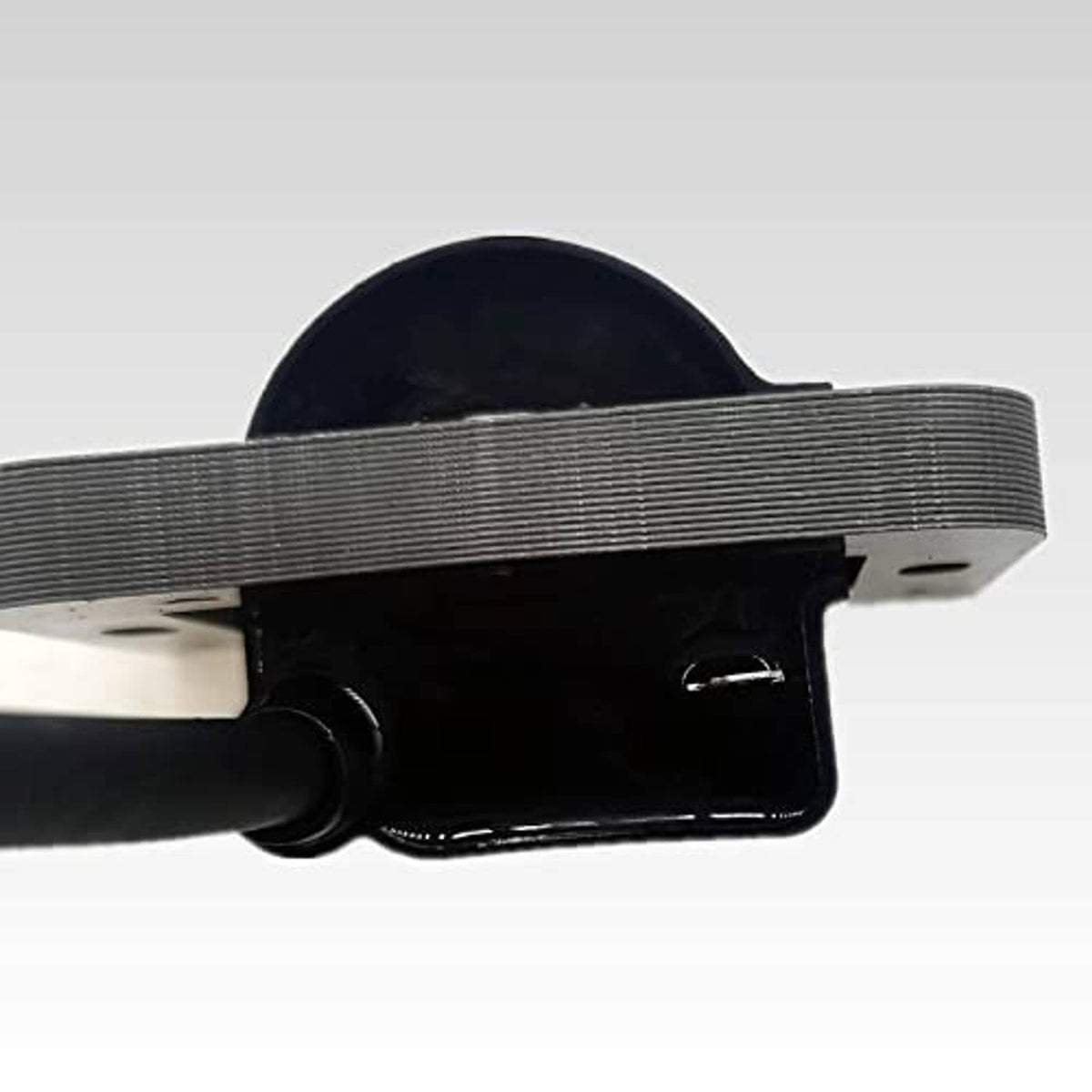 Close-up of digital ignition coil module with black housing and ribbed metal mount