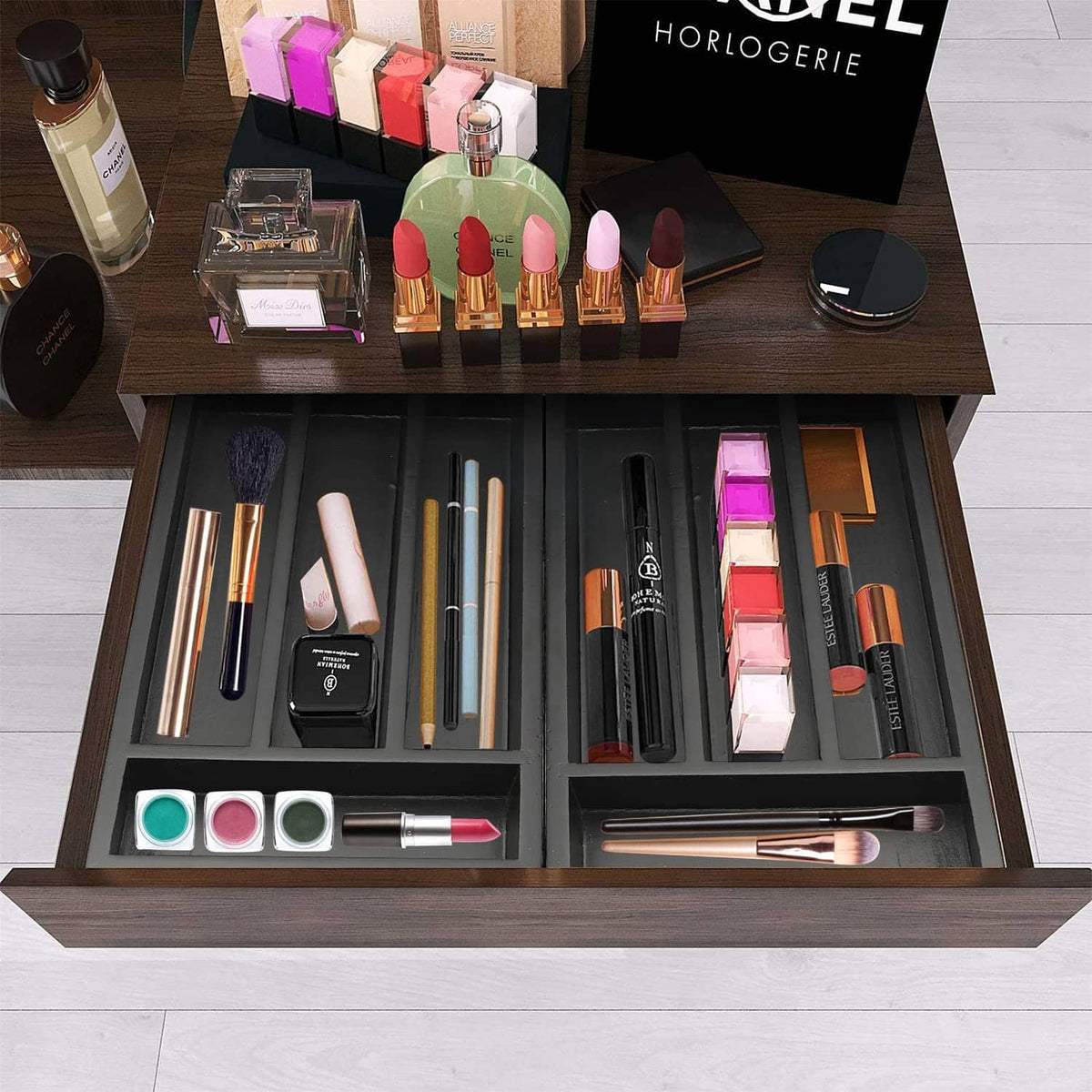 Black drawer organizer tray with separated compartments for cosmetics and tools