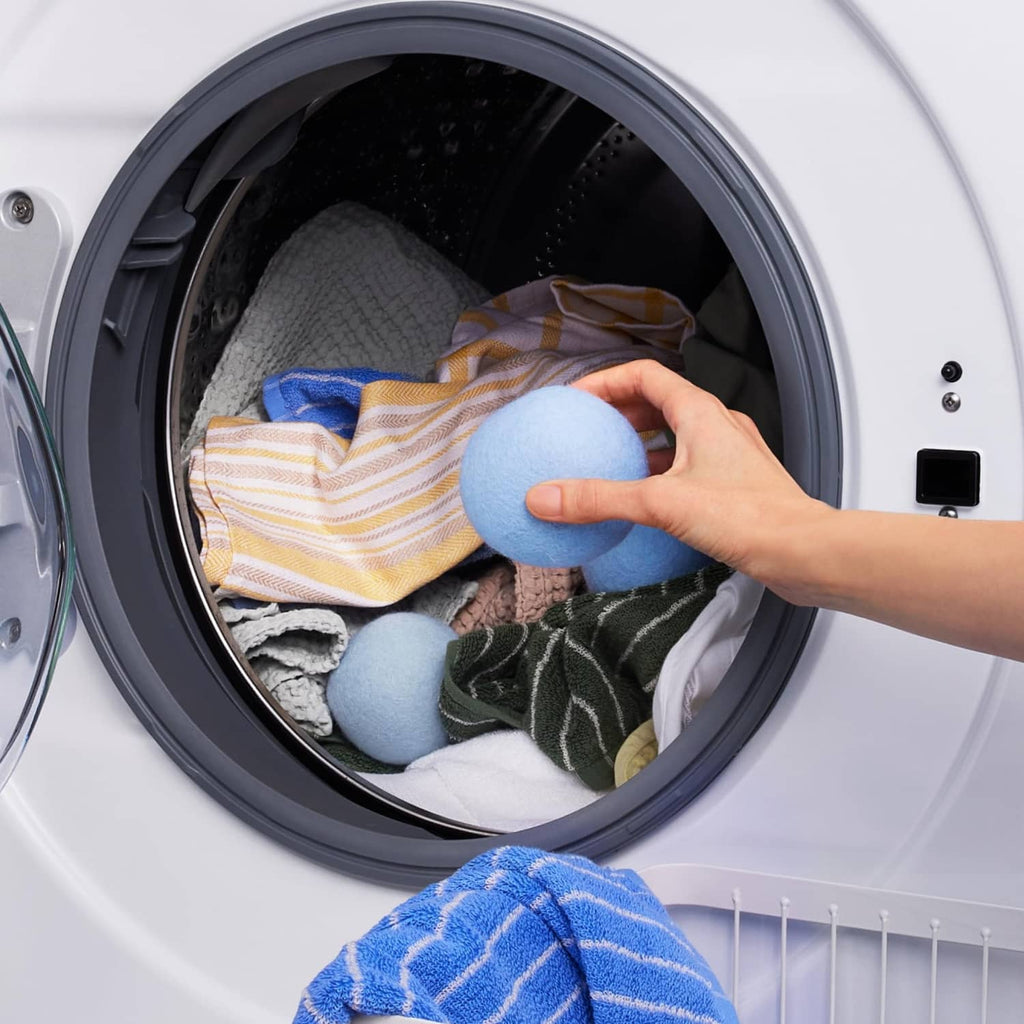 Washer drum with folded laundry and blue dryer balls