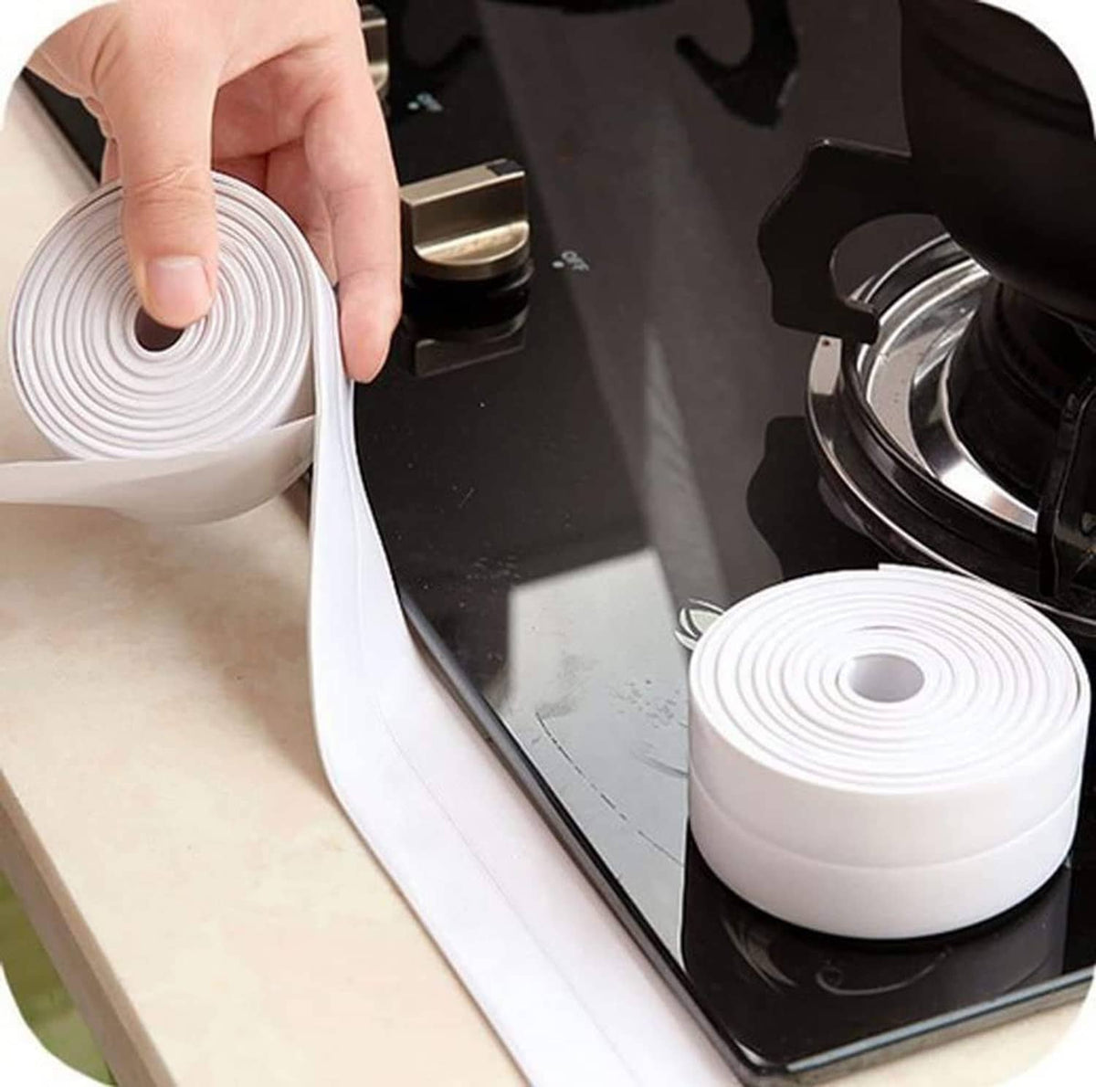 White caulk tape roll held by hand, strip ready to seal a sink edge