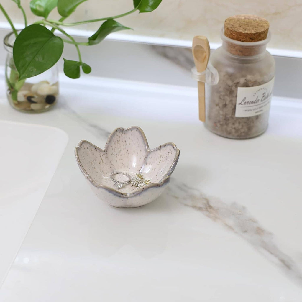 Ceramic flower-shaped jewelry tray with a ring and pearl floral charm