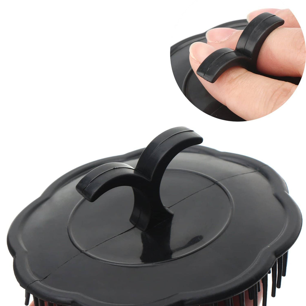 Black scalp massage brush with oval pad, raised handle, and dense bristles