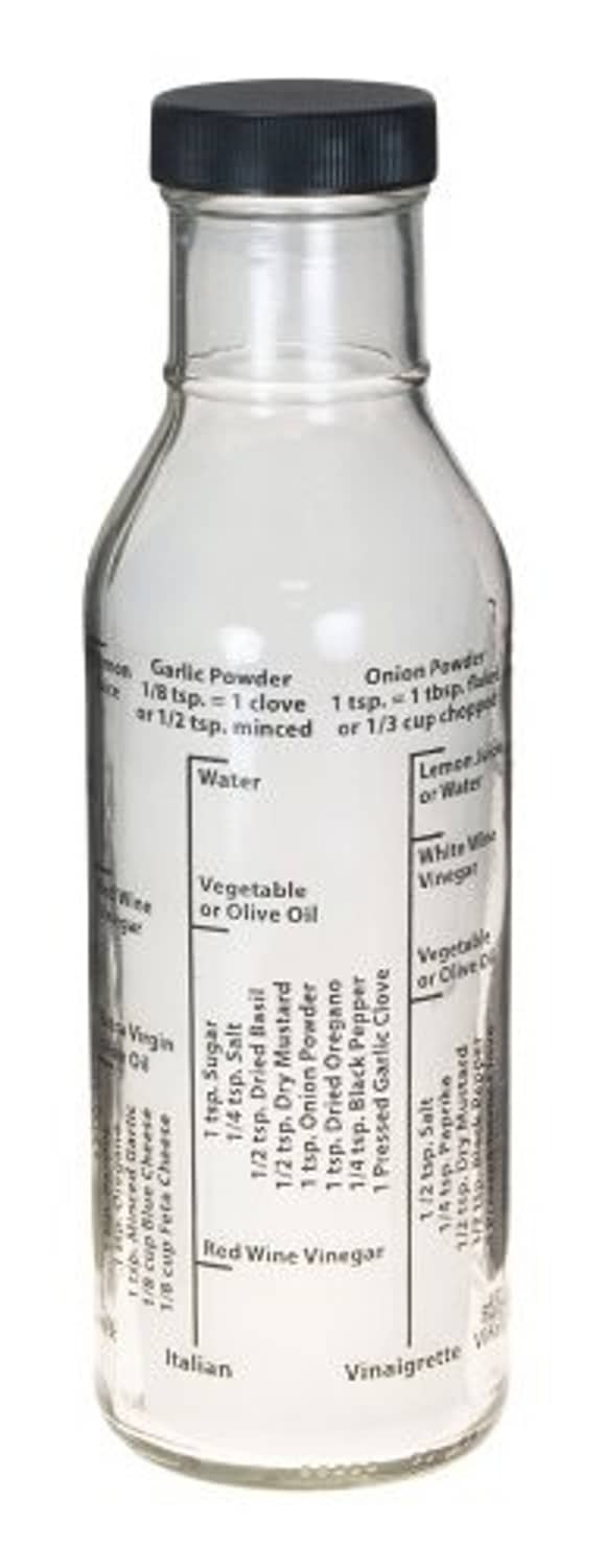 Glass salad dressing bottle with black cap, white liquid inside
