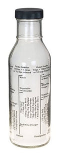 Glass salad dressing bottle with black cap, white liquid inside