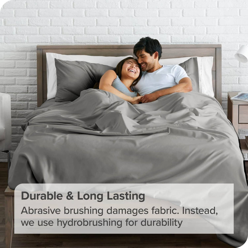 Light grey flat sheet on bed with two people resting under it