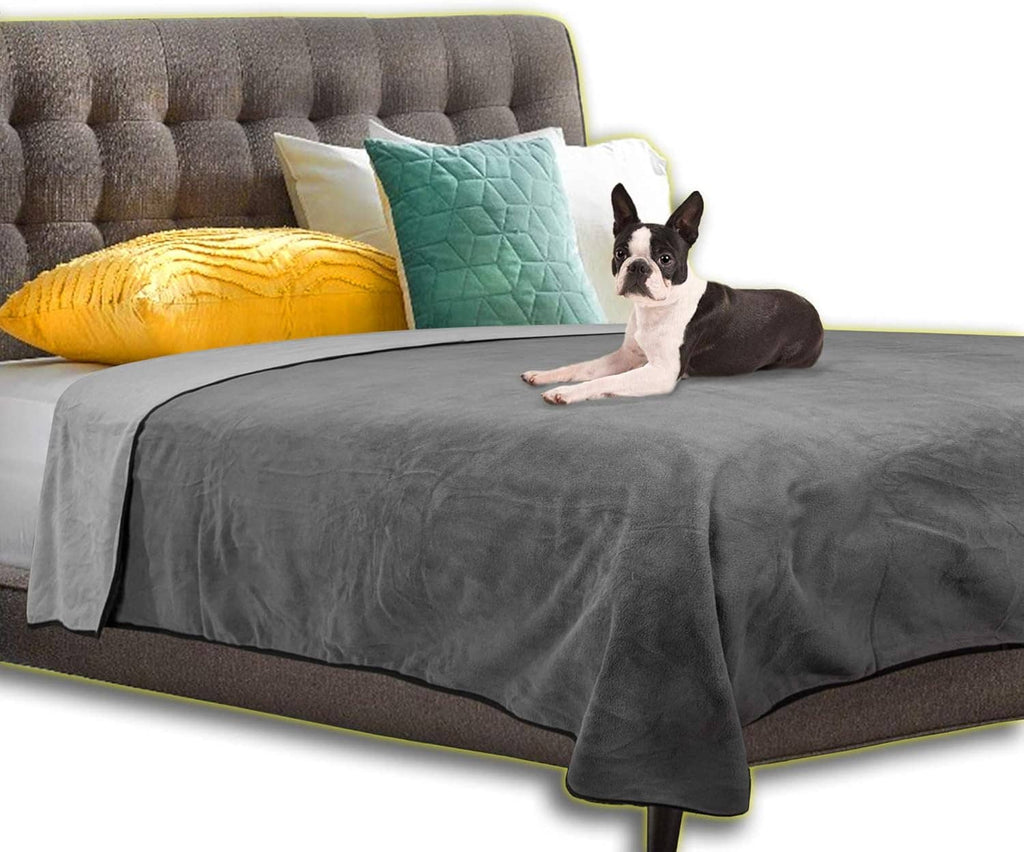 Gray waterproof bed cover draped over a bed with quilted mattress pad and pet dog