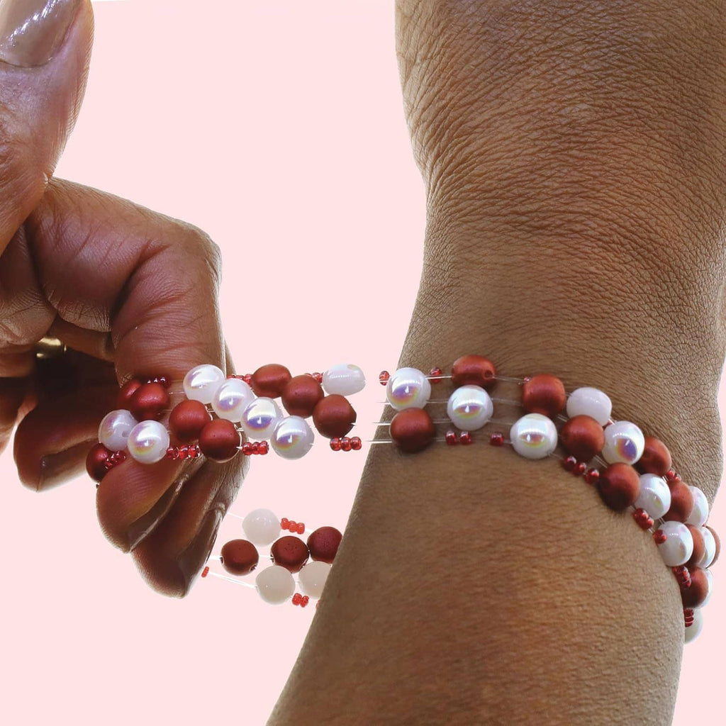 Elastic bead cord bracelet on wrist with clear cord and red bead accents