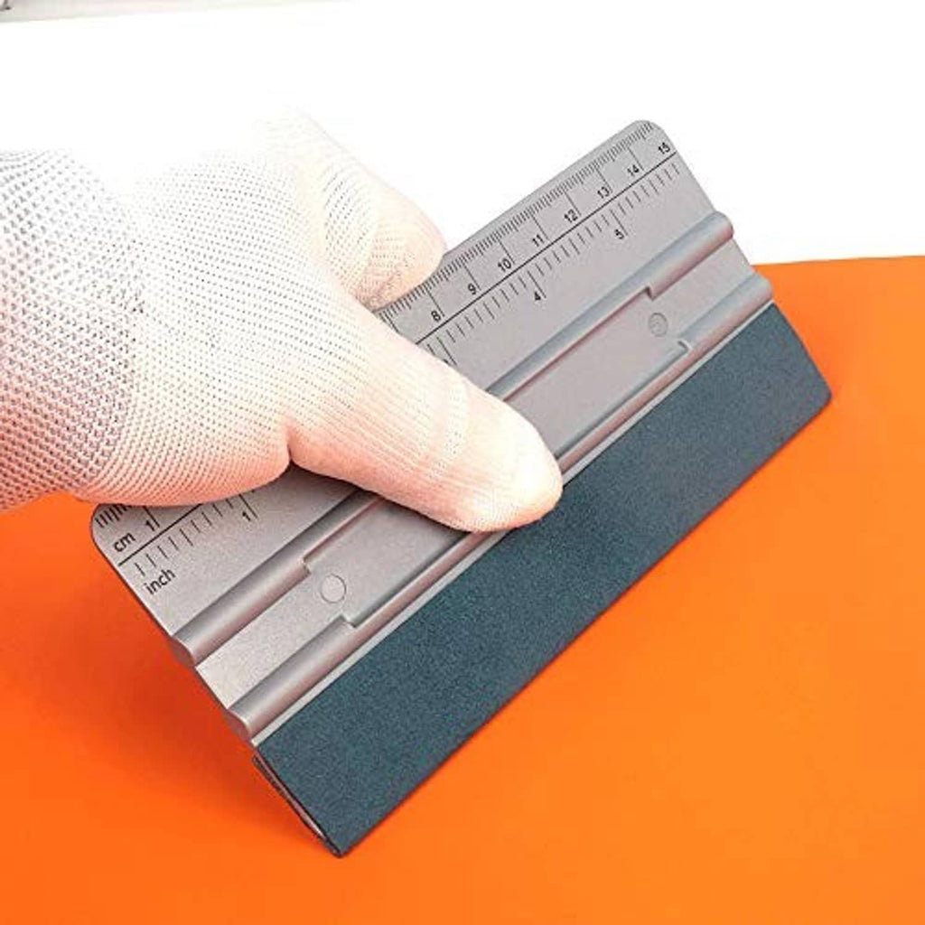 Hand holding 6-inch vinyl wrap squeegee with teal pad on orange surface
