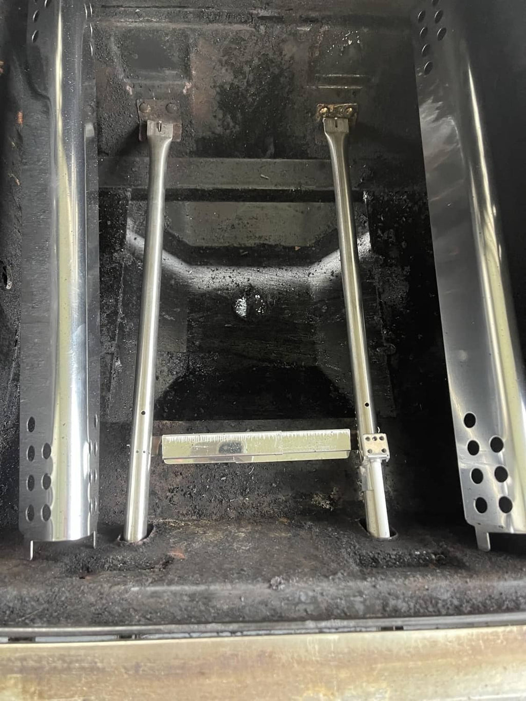 Stainless steel burner tube assembly installed inside a grill firebox