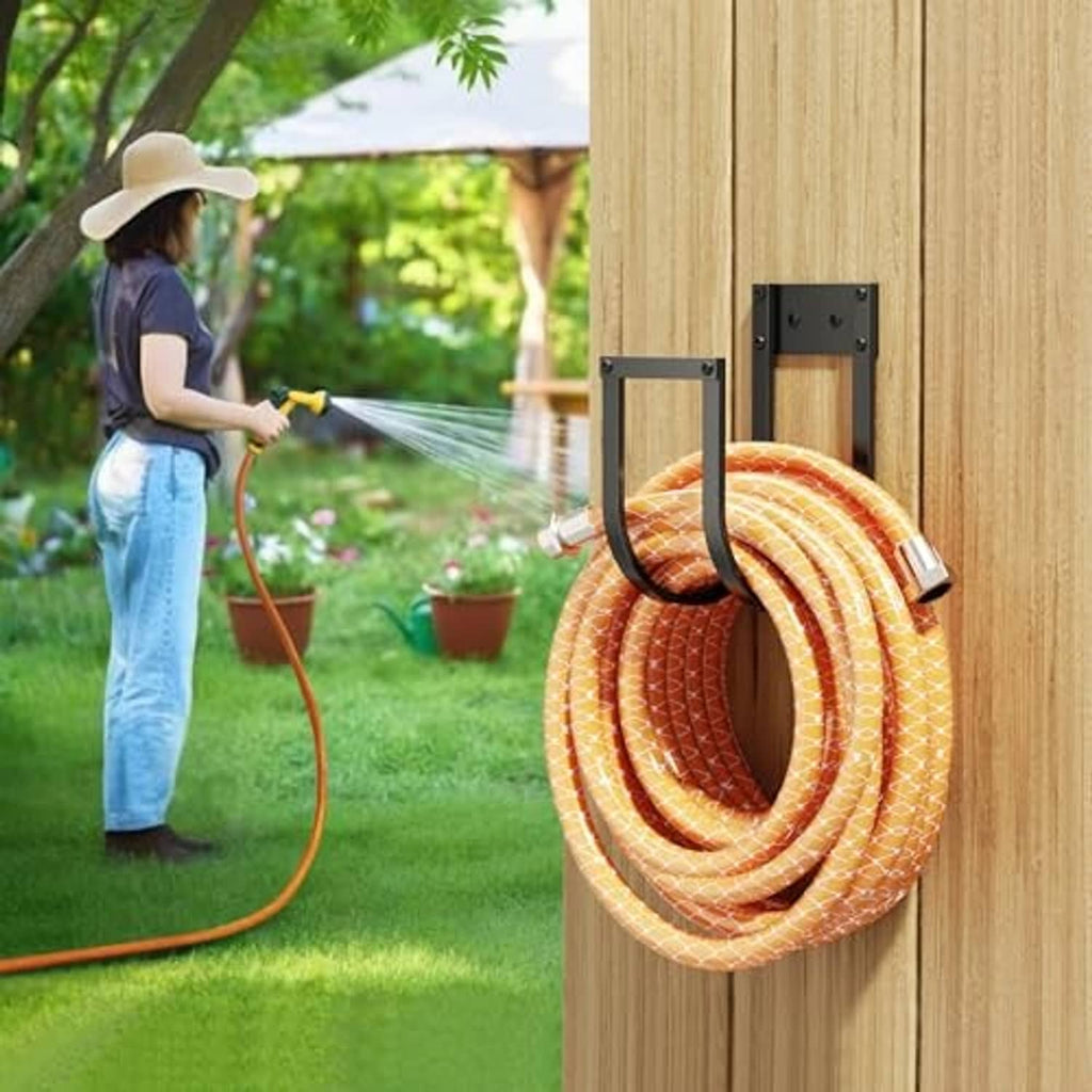 Wall-mounted hose hanger with dual hooks holding orange striped garden hose