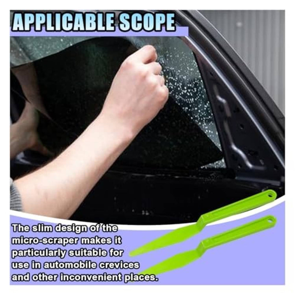 Bright green window tint squeegee tool lying along car glass surface for trimming