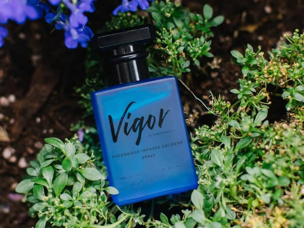 Vigor cologne bottle with black sprayer among green plants