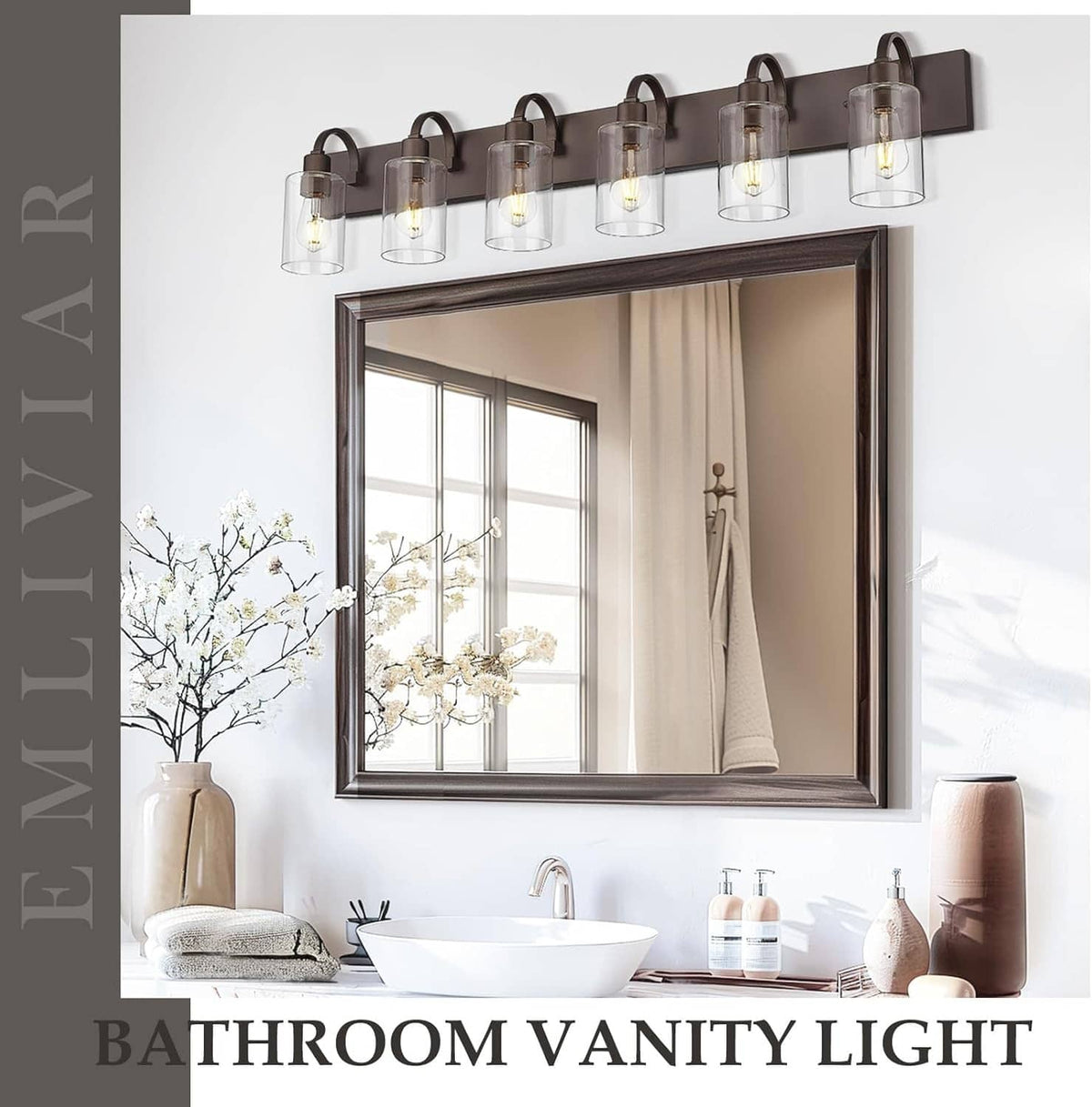 Bathroom vanity light with dark bronze bar and clear glass cylinder shades over mirror