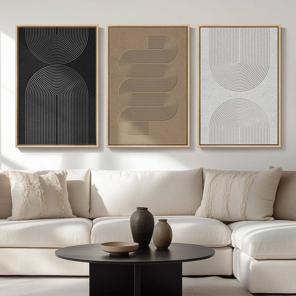 Three framed abstract line art panels in dark black, sand beige, and pale gray