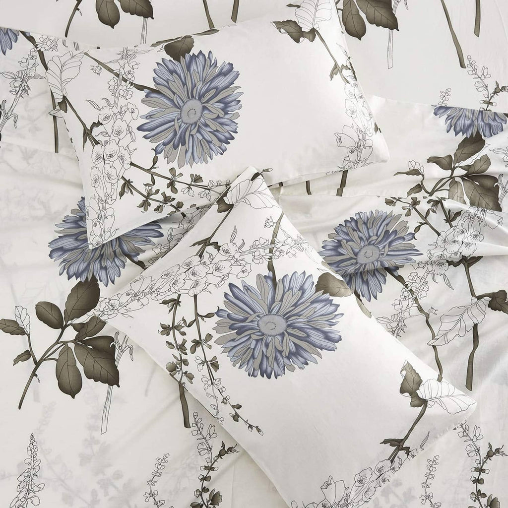 White bed sheet with blue chrysanthemum-style floral print and leafy botanical details