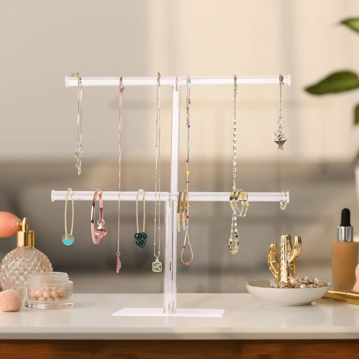 Clear acrylic necklace holder stand with multiple hanging chains and accessories