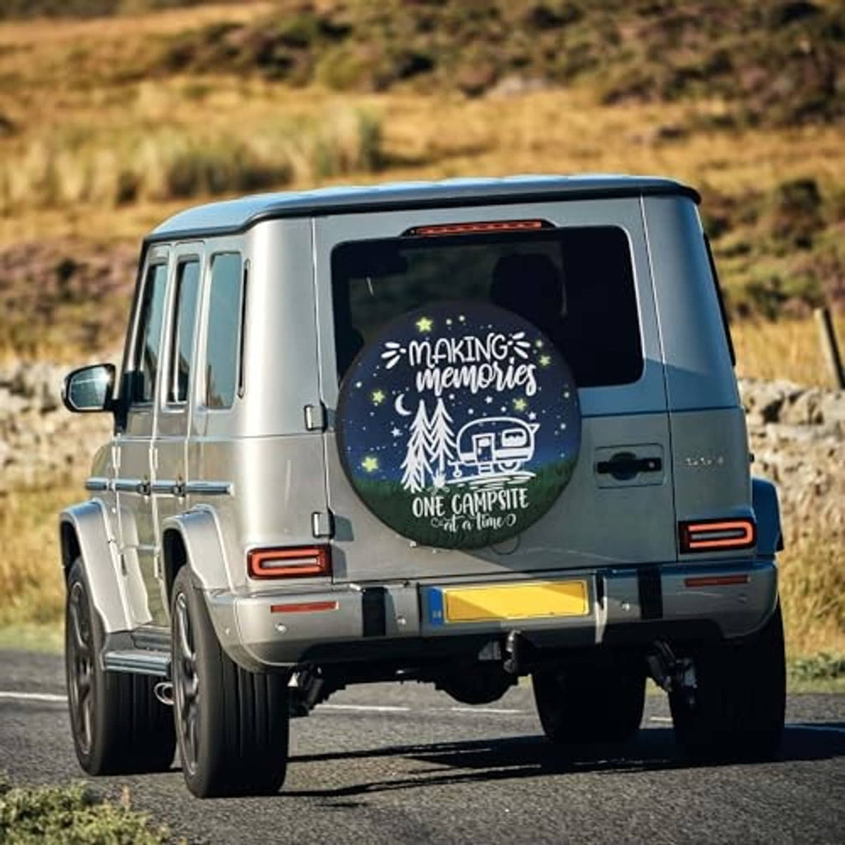 Spare tire cover on rear of RV, round dark blue camping print visible