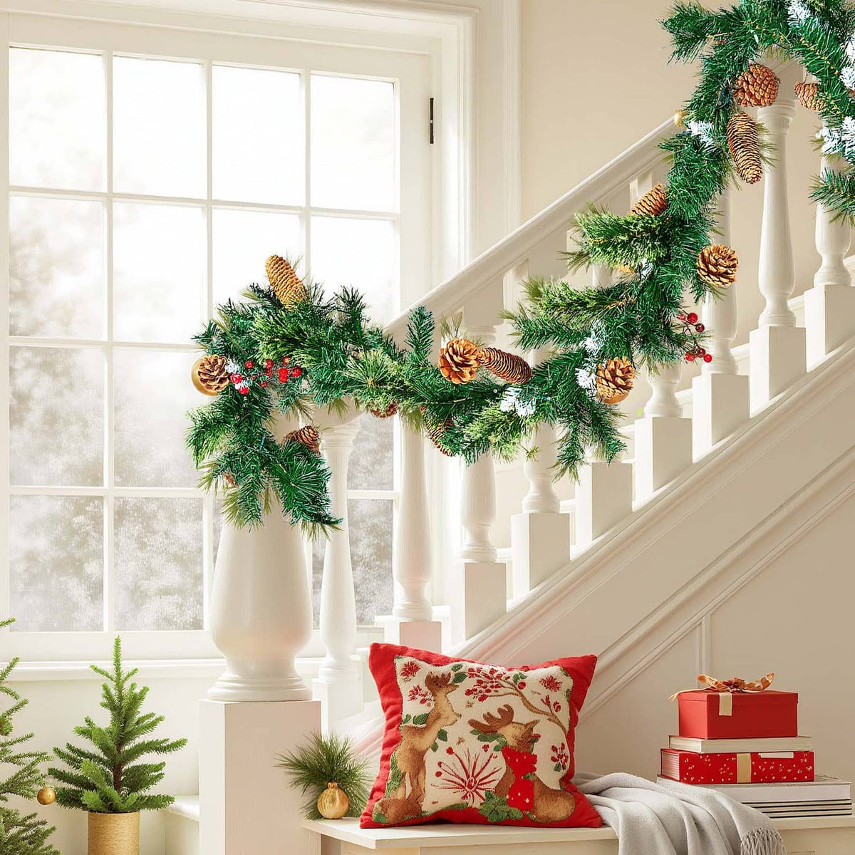 Christmas garland with pine needles, pinecones, and red berries on staircase railing
