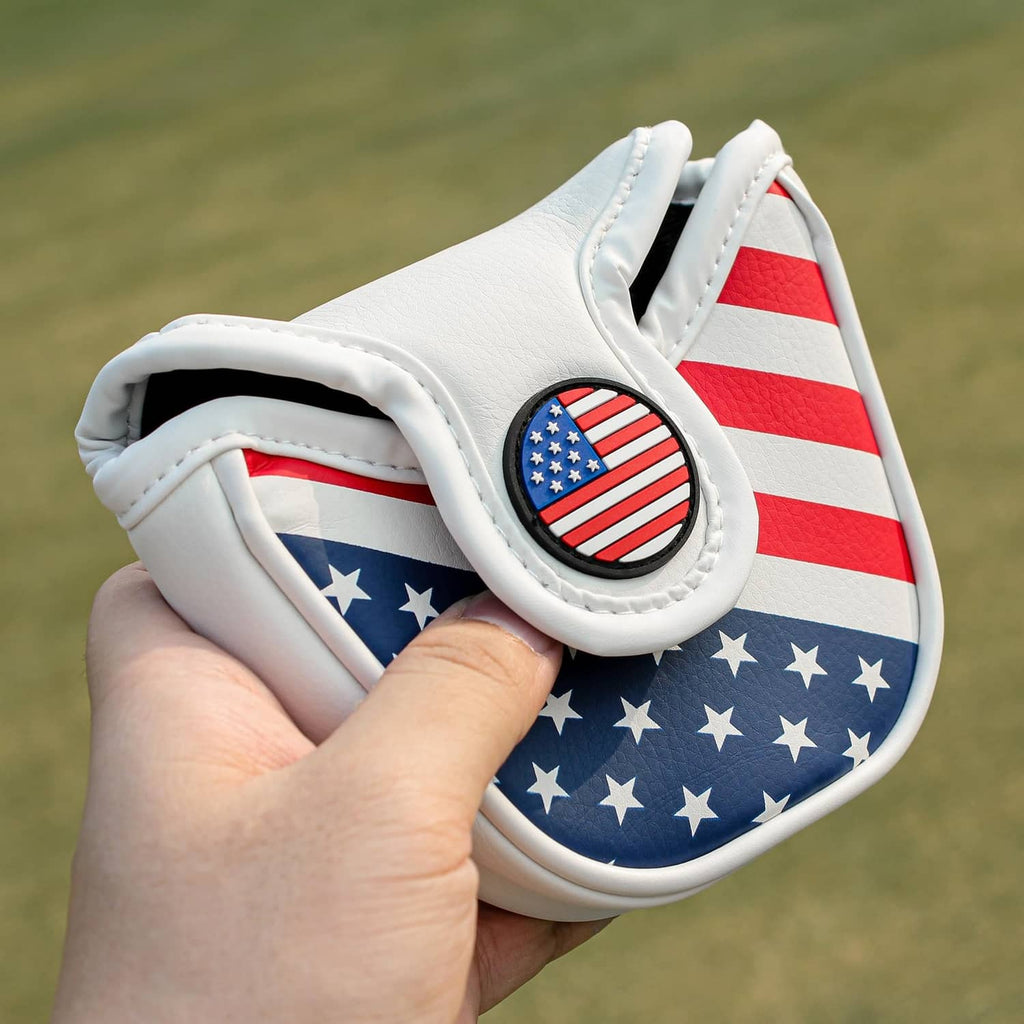 White mallet golf putter head cover held in hand, U.S. flag design with circular emblem
