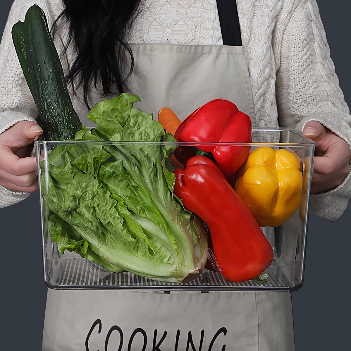 Clear plastic storage bin with side handles, holding mixed vegetables