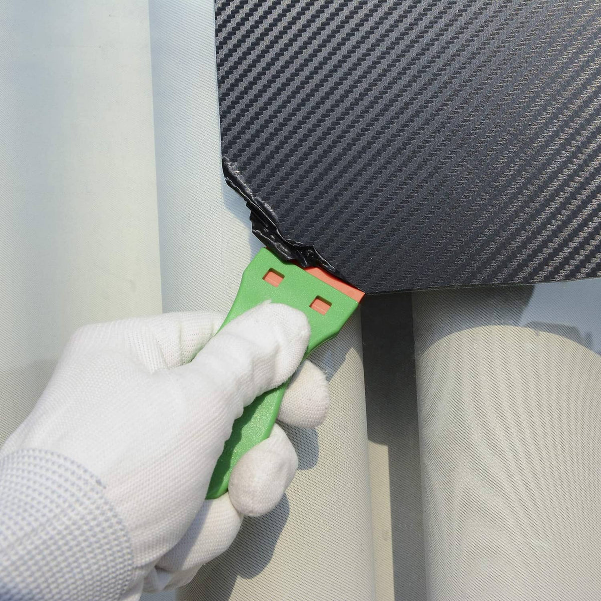 Green plastic scraper with orange blade insert for edge cleaning