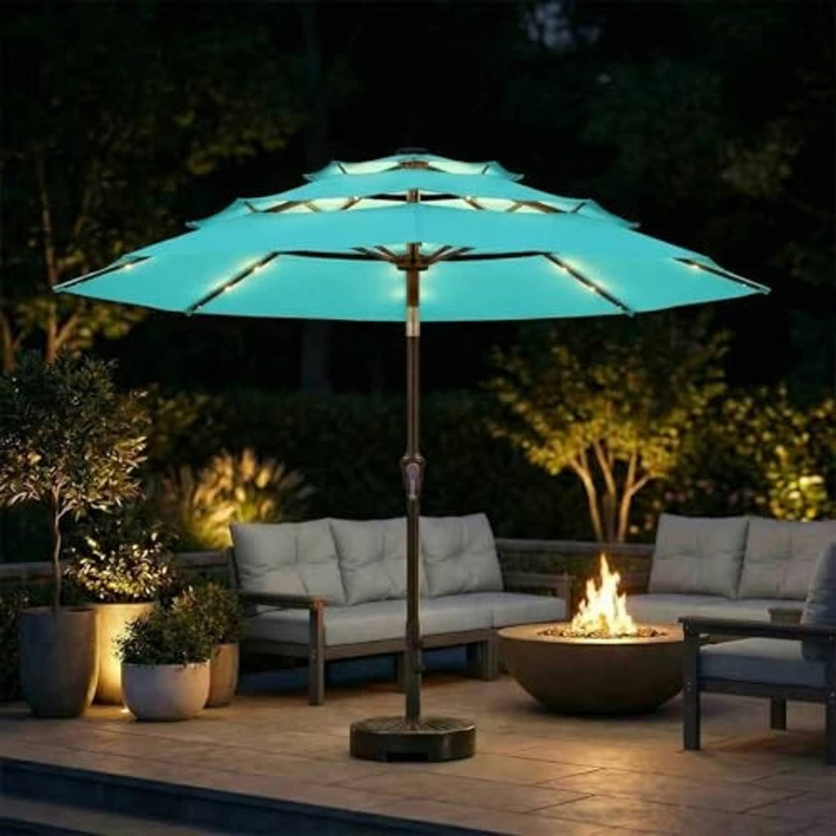 Aqua blue 3-tier patio umbrella with solar LED lights glowing at night.