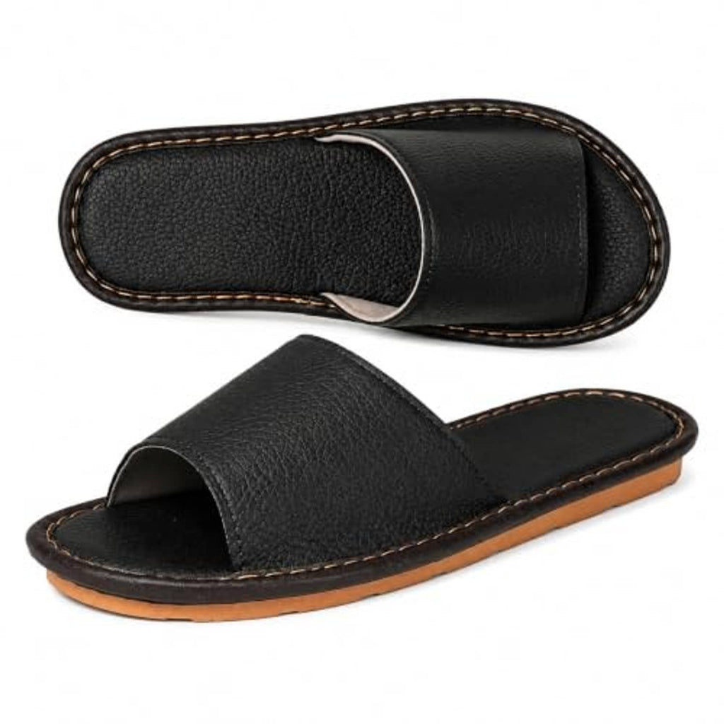 Black wide-strap open-toe slide flat sandal slipper with tan-trimmed outsole.