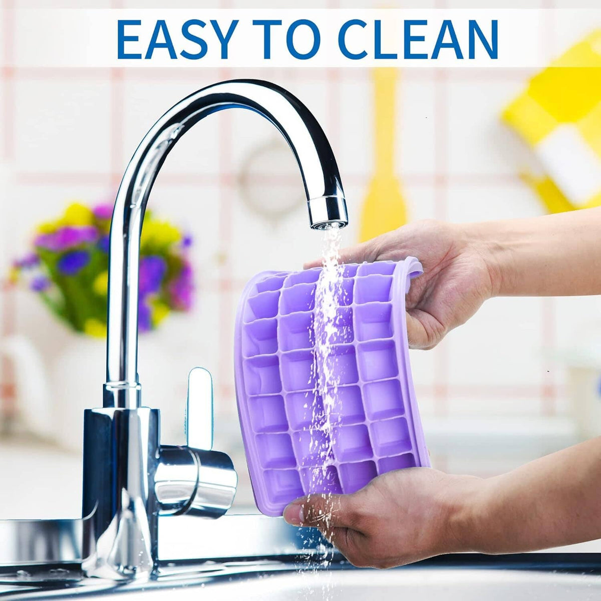 Purple silicone ice cube tray rinsed under a kitchen sink faucet
