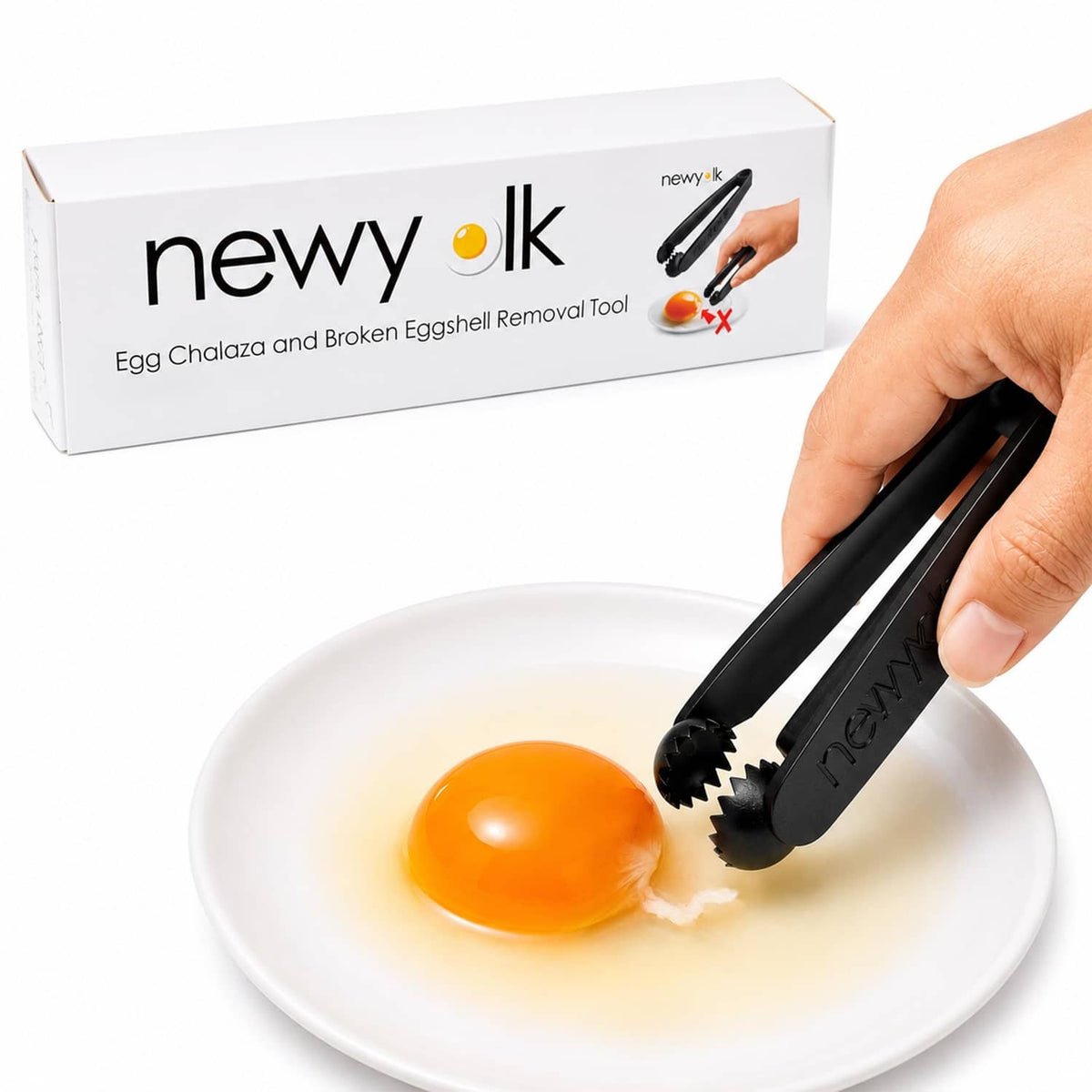 Black egg chalaza remover tool holding a yellow egg yolk on a white plate
