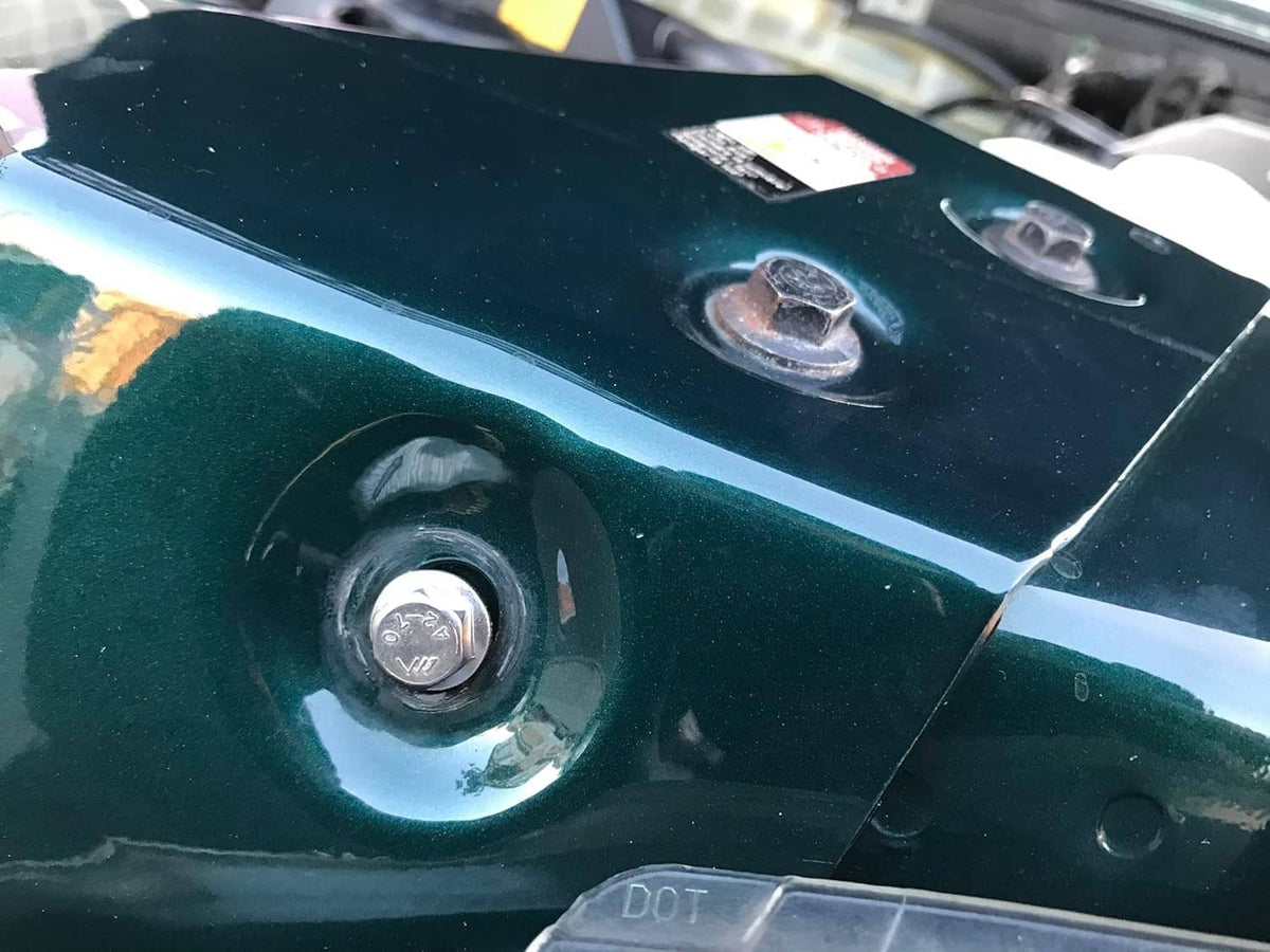 Close-up of a flanged hex head bolt securing a metal panel