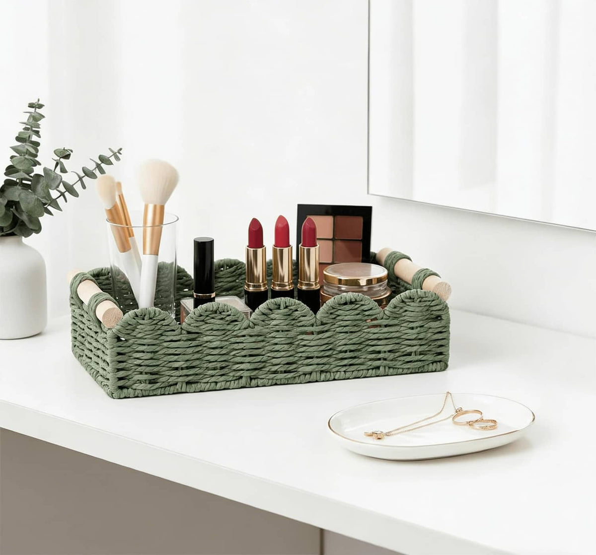 Green woven toilet paper storage basket with side loop handles on vanity countertop