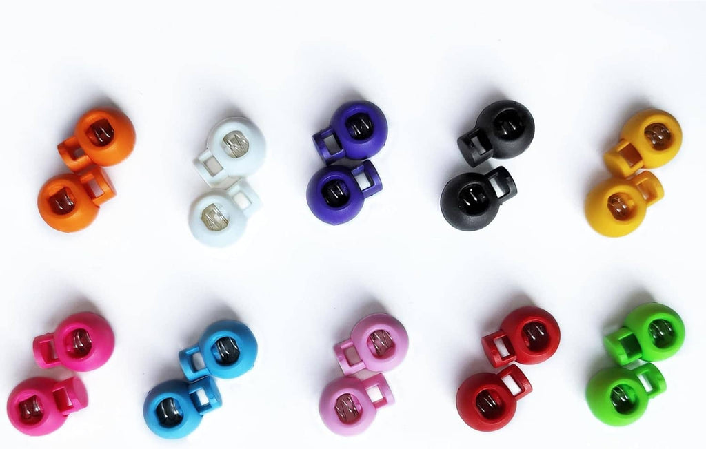 Multicolor plastic knitting needle stoppers arranged in rows, each with spring core.