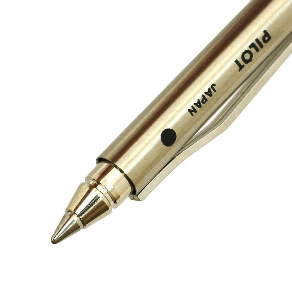 Gold pen barrel close-up with Pilot branding and pointed tip, black dot detail