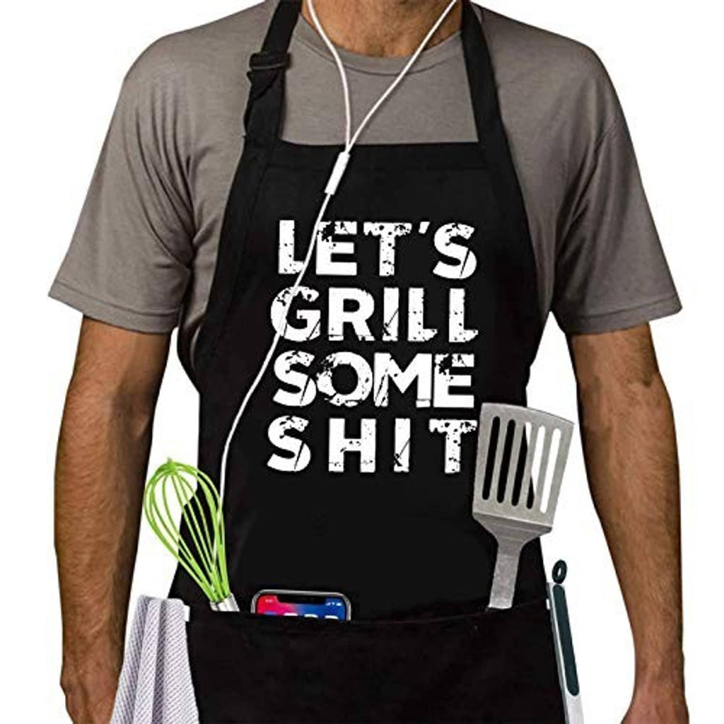 Black BBQ apron worn by man, "LET'S GRILL SOME SHIT" text with hanging grill utensil