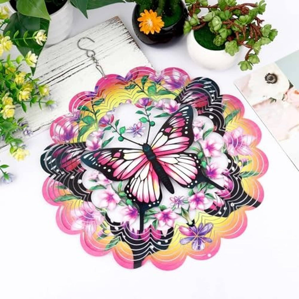 Pink and black butterfly wind spinner with layered paper petals, hanging hook at top.